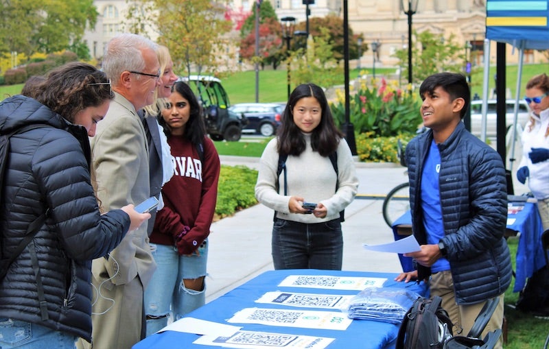 students and staff standing around a table