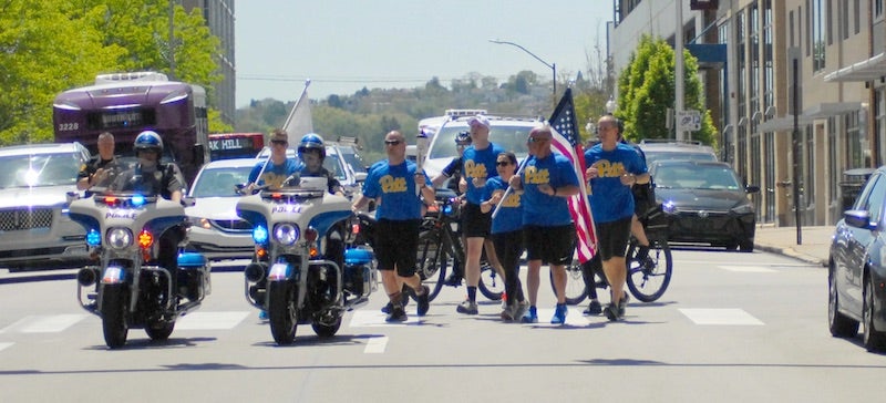 Pitt Police officers running up Forbes avenue with Police escort