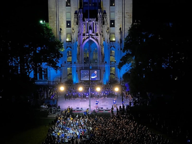 crowd of people and stage in front of the Cathedral of Learning