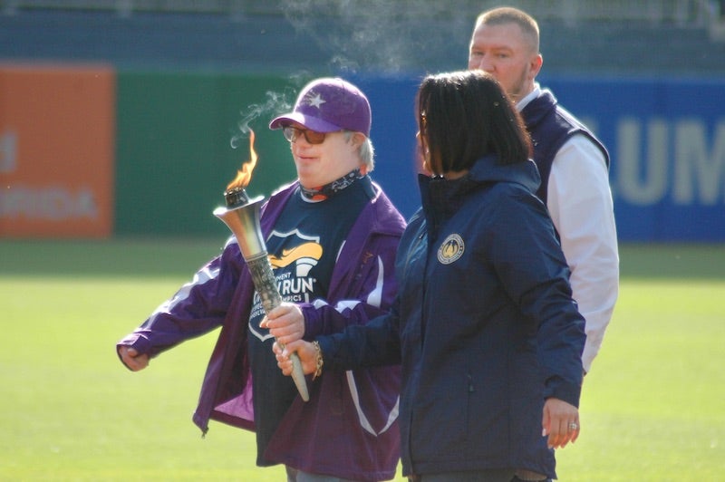 Two people carrying the Special Olympics torch