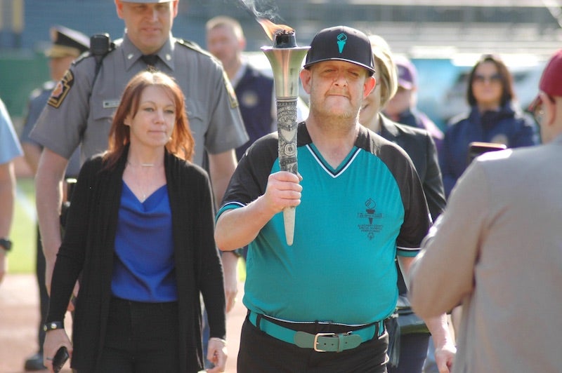 Person walking with the Special Olympics Torch