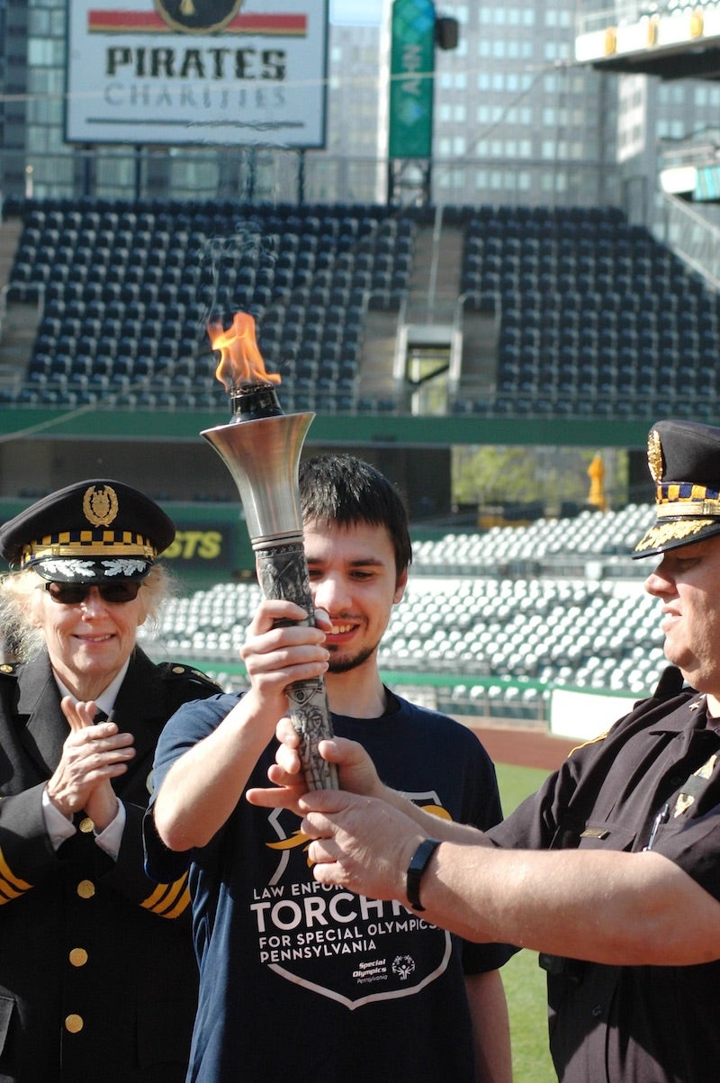 Two people holding the Special Olympics torch