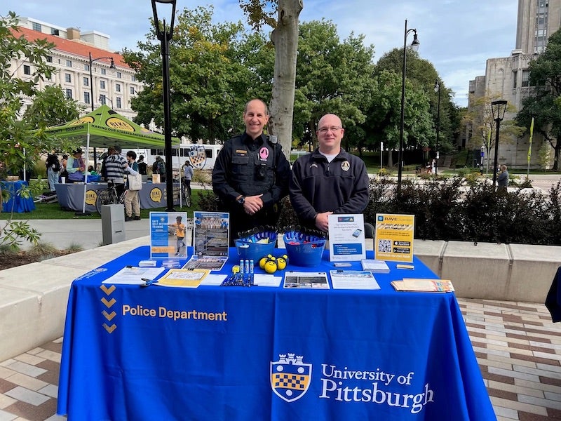 two police department staff standing at an informational table