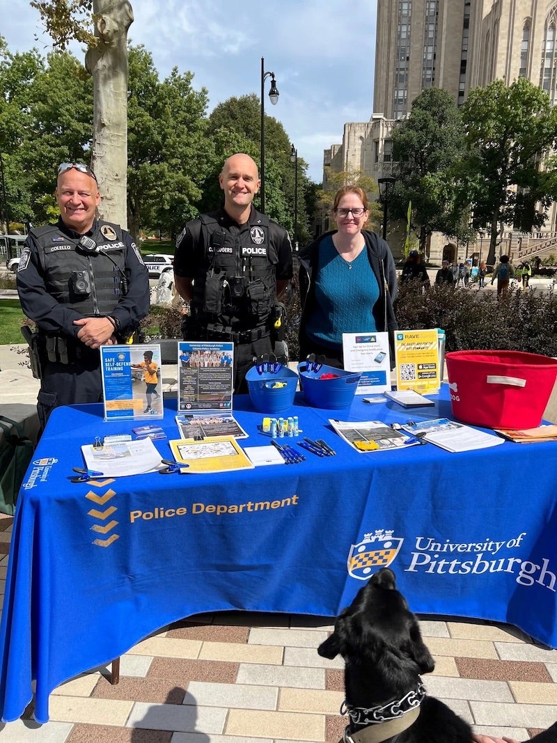 three police department staff standing at an informational table