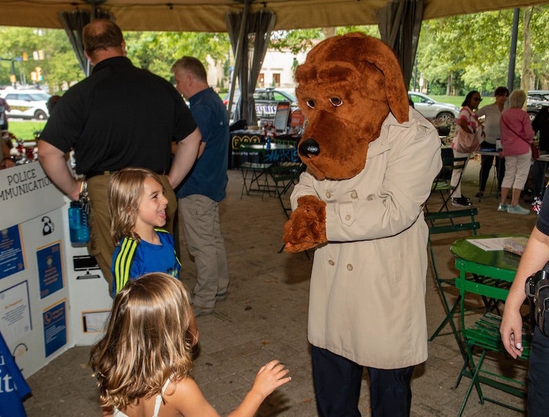 Dog mascot interacting with 2 children