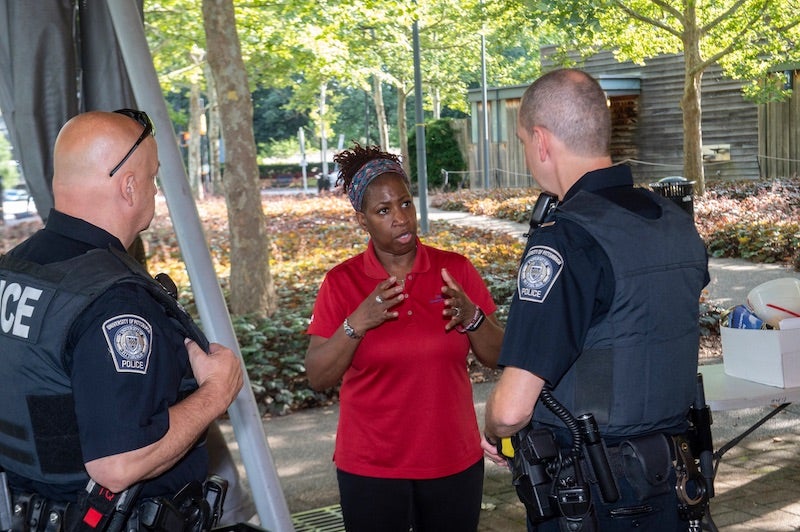 person interacting with two Pitt Police Officers