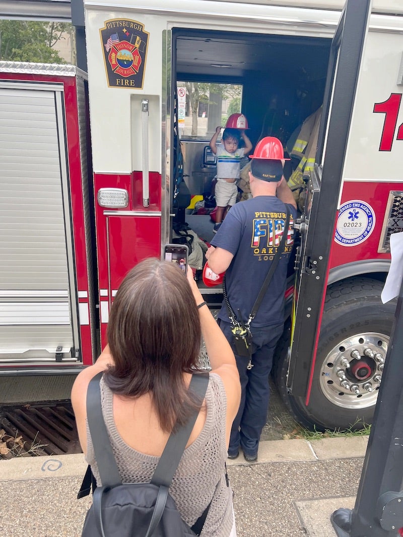 a child putting on a helping inside a firetruck