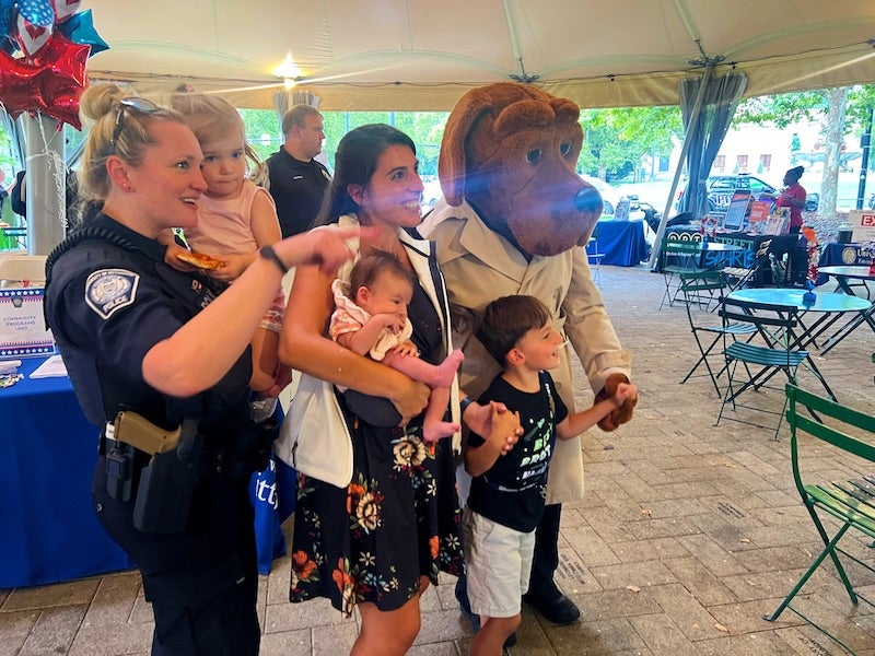 people posing for a photo with a dog mascot