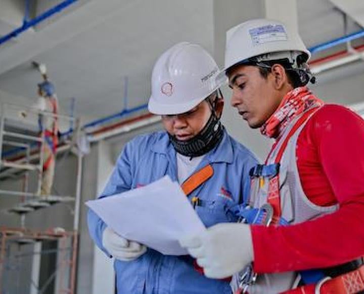 two people looking at a paper in a construction site