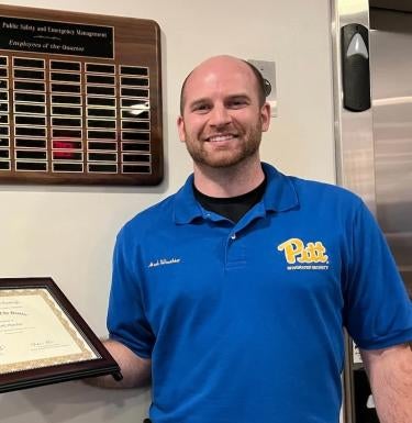 Mark Waechter holds his employee of the quarter certificate