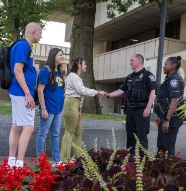 Pitt students on left shaking hands with Pitt police officers on right.